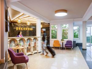 梅迪亚什Mercure Medias Binderbubi Hotel And Spa的穿过大厅接待区的人