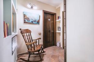 a wooden rocking chair in a hallway with a door at Hotel Il Convento in Naples
