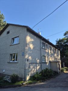 an old brick building with the sun shining on it at Zvaigžņu Apartment in Ogre