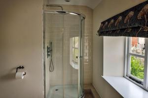 a shower with a glass door in a bathroom at Finest Retreats - Beili Glas Cottage in Penrhôs +28 photos