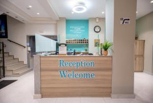 Un mostrador de recepción con un cartel de bienvenida en una tienda. en Amalia Mare Sea View, en Nea Vrasna