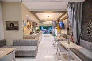 Un restaurante con mesas y sofás y un bar. en Amalia Mare Sea View, en Nea Vrasna