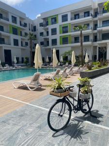 a bike parked in front of a swimming pool at Appartement avec piscine au coeur de la ville Mohammedia in Mohammedia