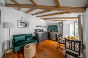ein Wohnzimmer mit einer grünen Couch und einer Küche in der Unterkunft My Little House in Paris * Hypercentre * Climatisé in Paris