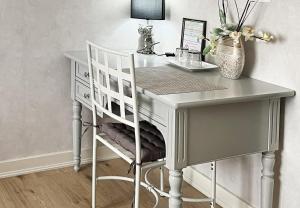 a white desk with a chair and a table at Villa Marguerite in Coutras