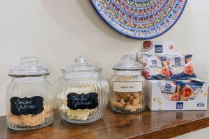 four glass jars sitting on a counter with food in them at Hotel Il Convento in Naples