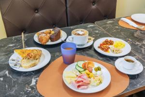 a table with plates of breakfast foods and cups of coffee at Hotel Il Convento in Naples