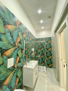 baño con un mural de hojas en la pared en Royal Dream, en Nápoles