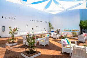 um quarto grande com cadeiras brancas e flores em The Lince Ecorkhotel Évora em Évora