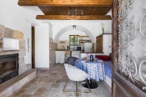 a living room with a table and a fireplace at Trullo Il Cavaliere by BarbarHouse in Padresergio