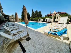 a group of lounge chairs next to a swimming pool at Horizont Apartments in Sunny Beach