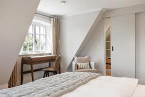 une chambre avec un lit, un bureau et une fenêtre dans l'établissement Gardenlodge 2, à List auf Sylt