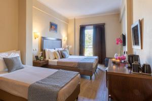 ein Hotelzimmer mit zwei Betten und einer Couch in der Unterkunft Hotel Marina in Athen