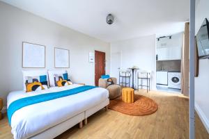 een slaapkamer met een groot bed en een keuken bij Magnifique studio proche de la capitale in Issy-les-Moulineaux