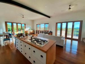 a kitchen and living room with a stove top at Birds Heaven Mareeba in Mareeba