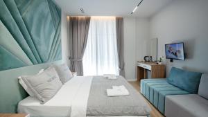 a hotel room with a bed and a couch at Hotel Saly in Durrës