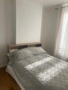 Cama en habitación blanca con marco de cama en mon appartement en centre ville, en Le Pré-Saint-Gervais 4 fotos más