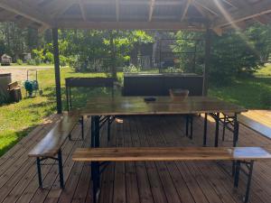 a wooden table and benches on a deck at Metsalagendik Apartments in Otepää