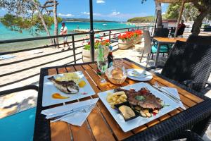 a table with two plates of food and the ocean at Camping Park Soline Mobile homes in Biograd na Moru