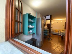 a kitchen with a refrigerator and a living room at La casa di Carlotta in Loano