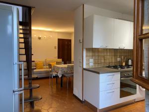 een keuken met witte kasten en een woonkamer bij La casa di Carlotta in Loano