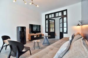 a living room with a couch and chairs and a tv at La Villa des Fontenelles - Proche de la mer in Carolles