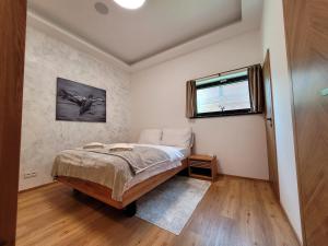 een slaapkamer met een bed en een raam bij Apartmán SPA - Chalet ONE Jasná in Demanovska Dolina +36 foto's