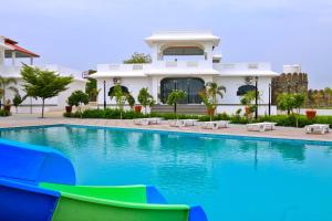 a villa with a swimming pool in front of a house at BA-NA Hills Resort in Salara