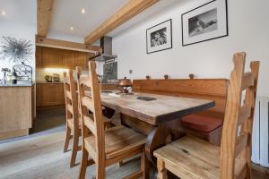 uma cozinha e sala de jantar com mesa e cadeiras de madeira em Appartement Clusettes - Happy Rentals em Chamonix-Mont-Blanc