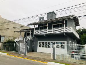 a house with a white fence in front of it at Pousada Orquídea Araquari in Araquari