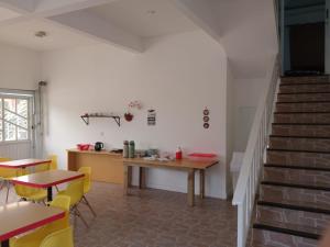 a room with a table and chairs and stairs at Pousada Orquídea Araquari in Araquari