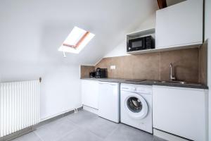 a white laundry room with a washer and dryer at Studio coloré proche Paris Parc des Princes in Issy-les-Moulineaux