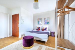 a bedroom with a bed and a purple ottoman at Studio coloré proche Paris Parc des Princes in Issy-les-Moulineaux