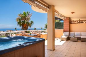 a hot tub on a patio with a view of the ocean at Malibu Mansions by the beach by ALFRESCO STAYS in Mijas Costa