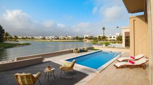 a pool with chairs and a view of the water at Villa Palmview in Salalah