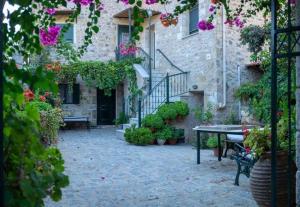 a courtyard of a building with a table and flowers at Olga's Home Oitylo in Oítilon