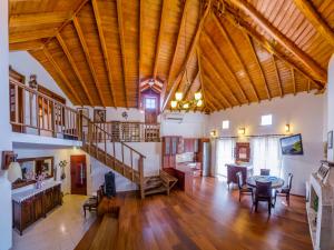 a large living room with a wooden ceiling and a staircase at Olga's Home Oitylo in Oítilon