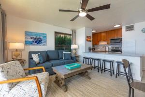 a living room with a blue couch and a kitchen at SUGAR BEACH RESORT, #235 condo in Kihei