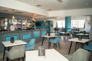 a restaurant with tables and chairs and a bar at Mercure Liverpool Atlantic Tower Hotel in Liverpool