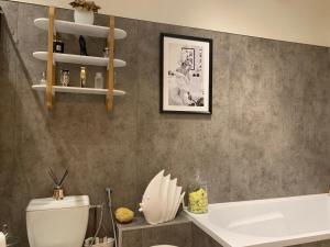 a bathroom with a toilet and a sink and a tub at Maison de ville in Saint-Jean-dʼAngély