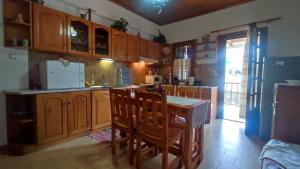 a kitchen with wooden cabinets and a table and chairs at Xrysanthi's dream house in Zagora