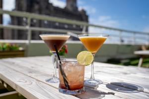 two cocktails in glasses sitting on a wooden table at Mercure Liverpool Atlantic Tower Hotel in Liverpool
