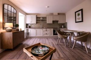 a kitchen with white cabinets and a table and chairs at 19 on the green in Belcoo