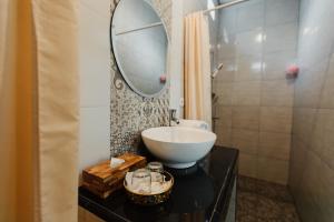 a bathroom with a sink and a mirror on a table at Dana's House in Tabanan +21 photos