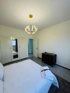 a bedroom with a large white bed and a chandelier at Appartement spacieux - BD Anfa in Casablanca +29 photos