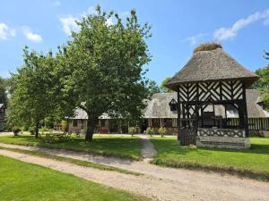 a gazebo in front of a house with a tree at la ferme chevalier in Équemauville