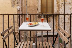 a table with a bowl of fruit and two glasses of wine at Hotel Il Convento in Naples