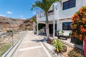 ein Haus mit einer Palme auf einem Gehweg in der Unterkunft Apartment Sabi Star Puerto Rico in Puerto Rico de Gran Canaria