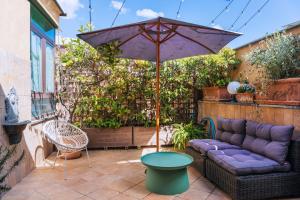 a patio with a purple couch and an umbrella at Hotel Il Convento in Naples