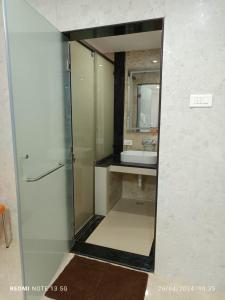 un bagno con doccia in vetro e lavandino di Arasan Residency a Kotagiri Altre 18 foto